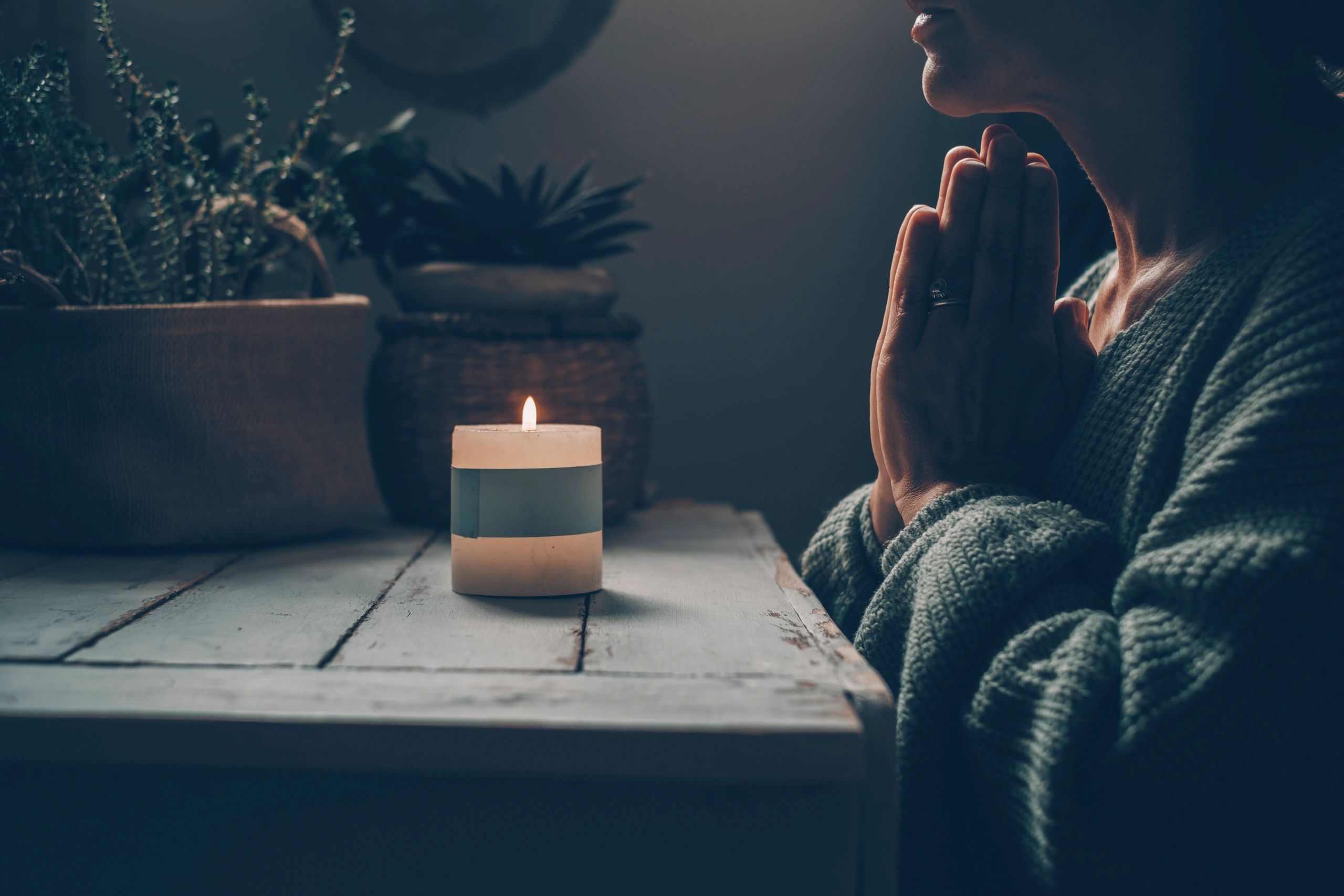 Person praying by candlelight