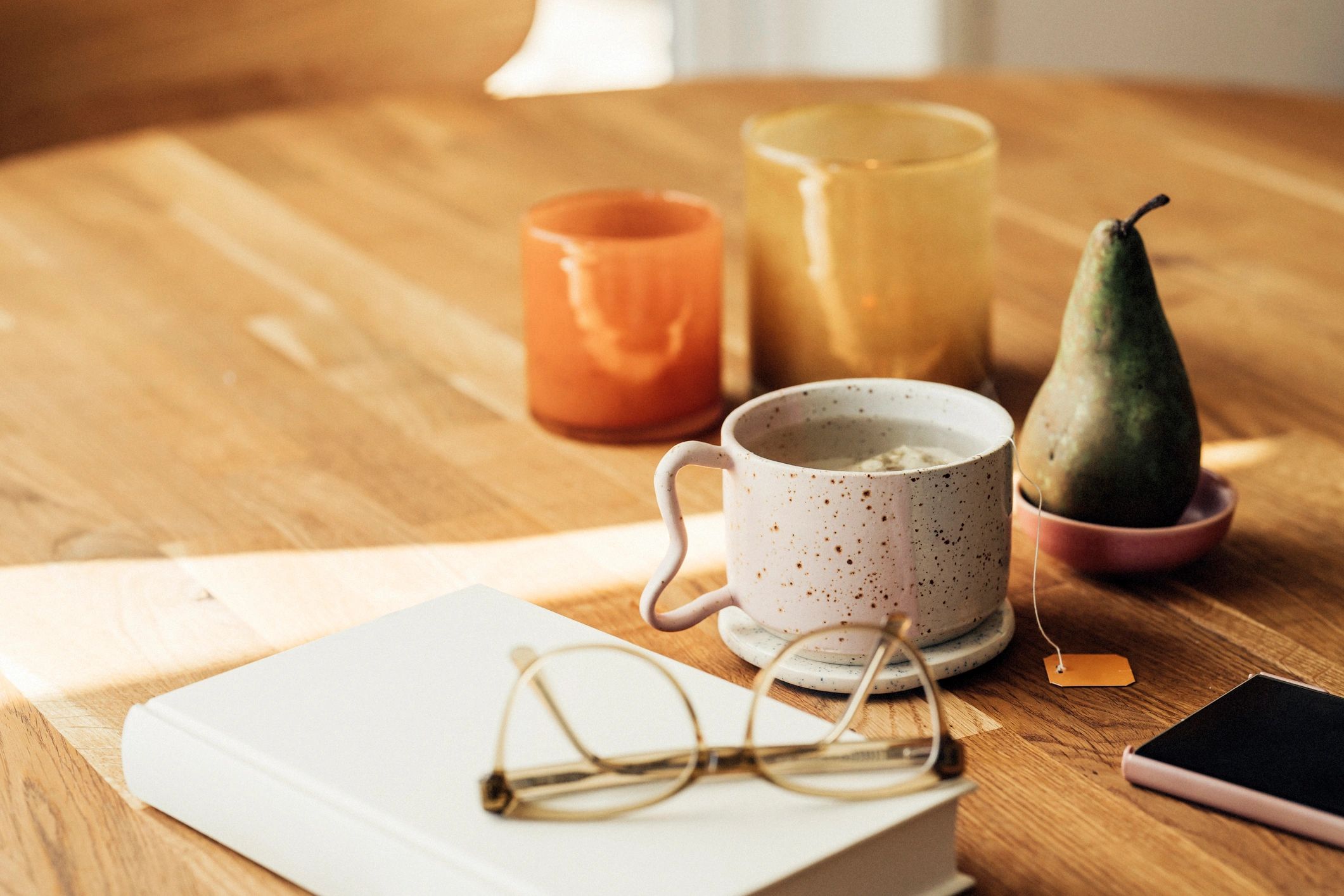 Tea, candles and book on a warm table