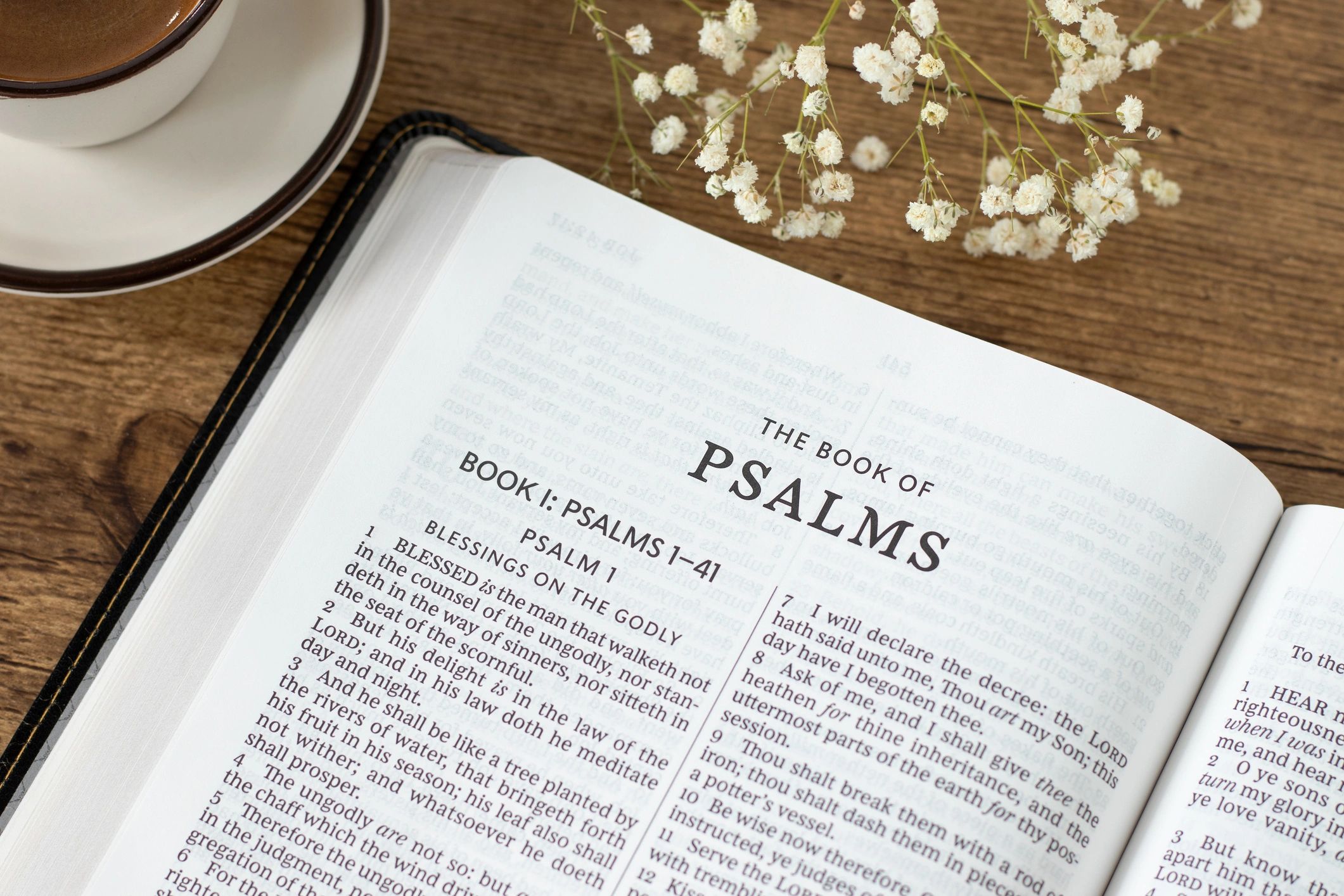Open Bible and coffee cup on a wooden table